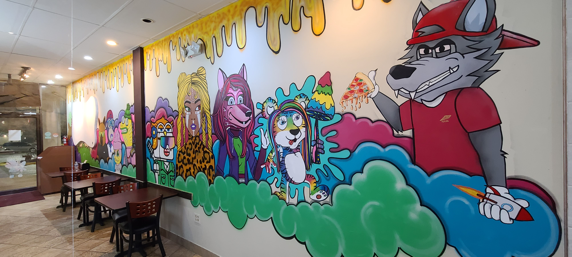 Stone Hot Pizza mural — full wall view with pizza-slinging wolf mascot and character lineup