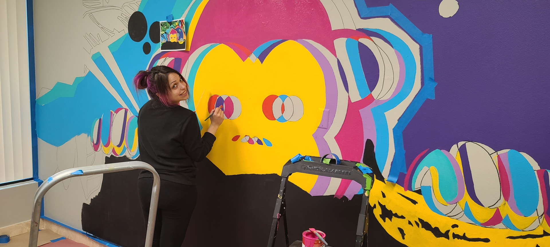 Red Chimp mural — Rebecca Henry painting the chimp face detail on-site