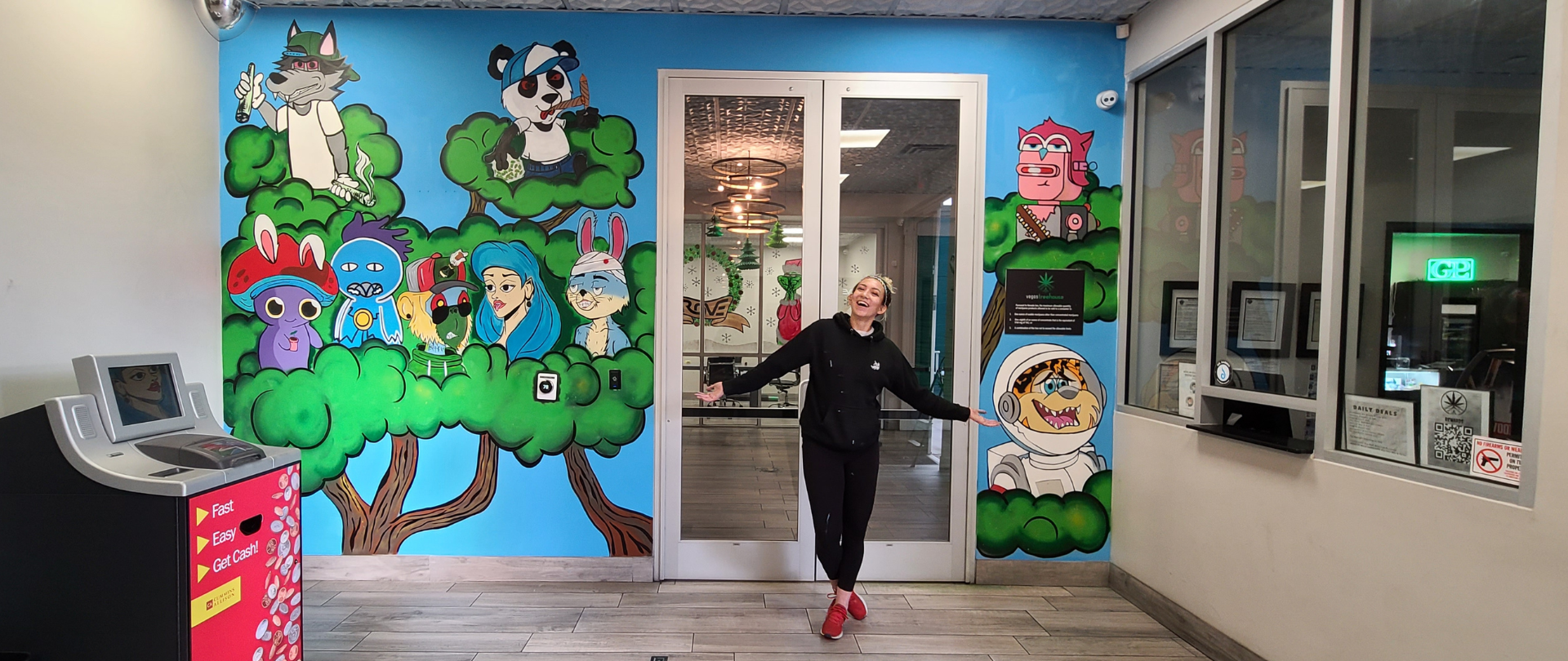 Vegas Tree House mural with artist Rebecca Henry in front of the completed lobby installation